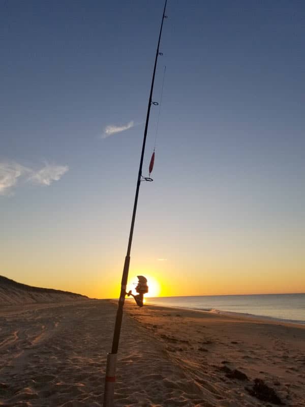 A fishing rod silhouetted in the sunset at Head of the Meadow Beach in Truro, MA